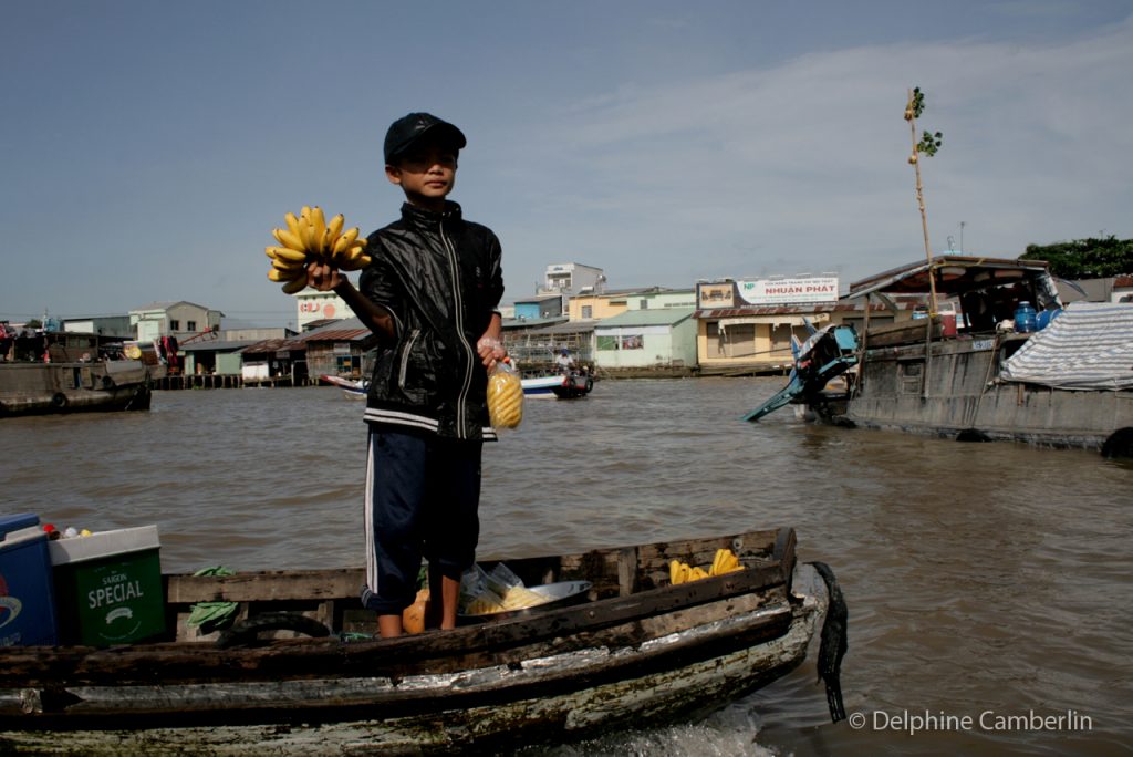 Child Selling banana on floating market