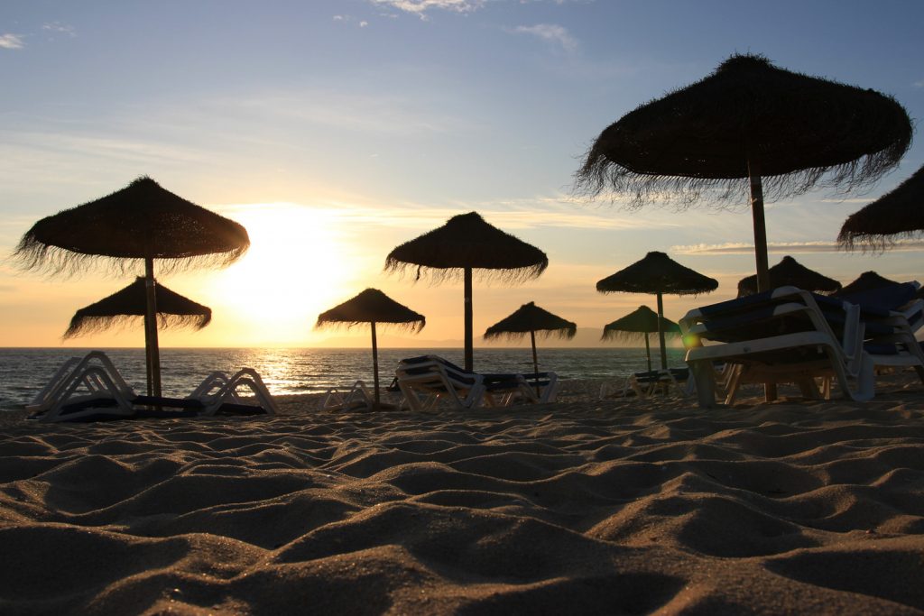 Beach umbrellas on sunset sand