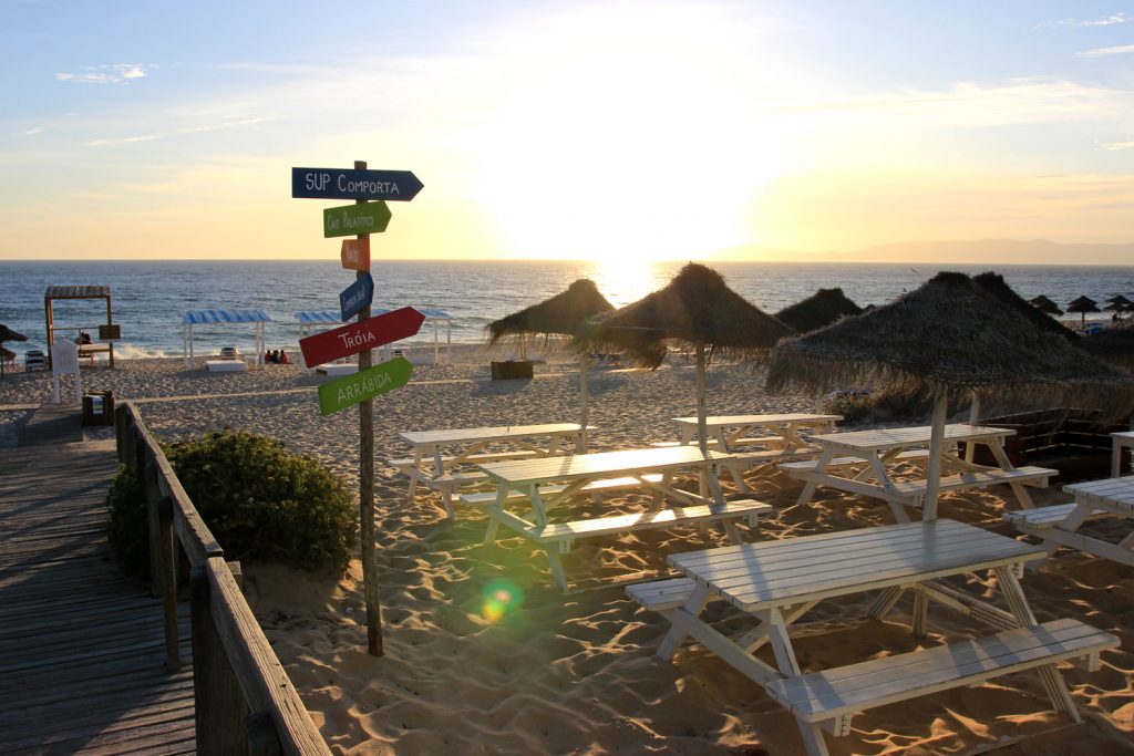 comporta beach sign with white table and umbrellas