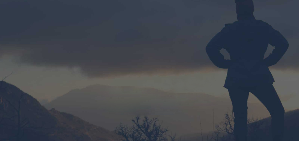 Woman on the top of the mountains looking at the sunset